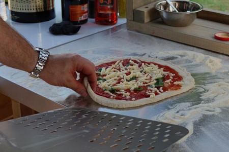 Hand die pizza deeg uitstrekt voor het maken van een verse pizza.