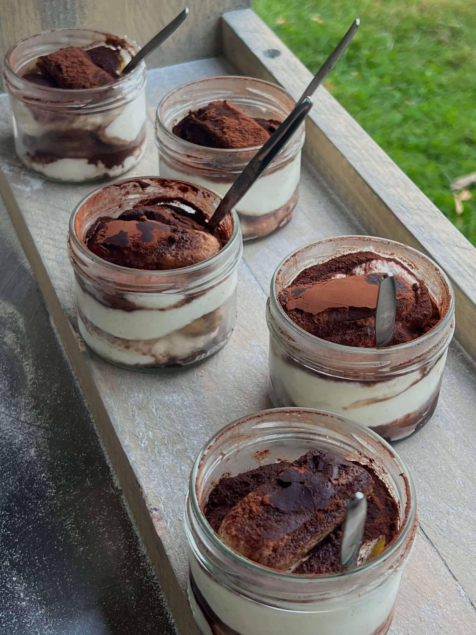 Tiramisu dessert in glazen potjes met cacao en chocolade, perfect voor catering en evenementen.